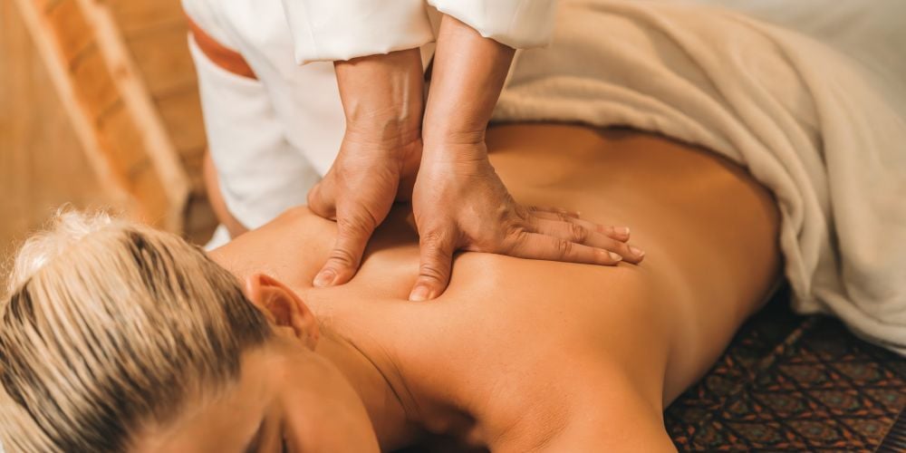 Woman receiving a back massage at a day spa.
